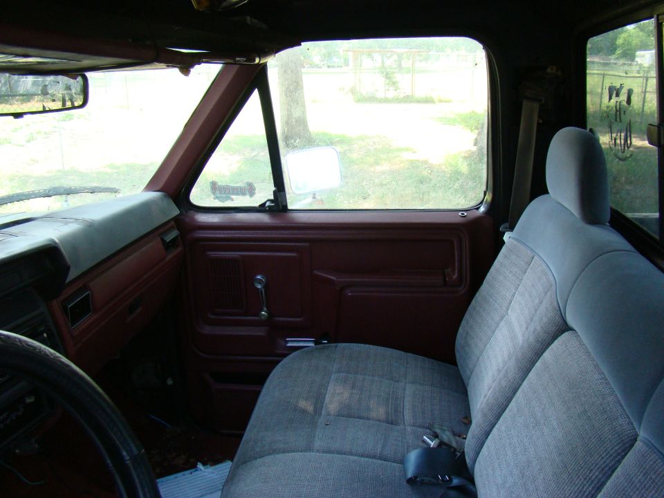 Interior of a pickup truck showing dashboard, door panel, steering wheel, and seats.