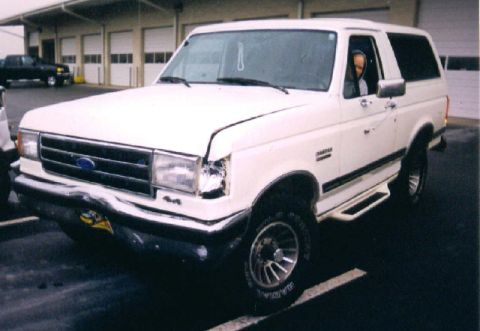 1989 Ford Bronco - White 1989 Ford Bronco with visible damage to the front bumper and headlight area.