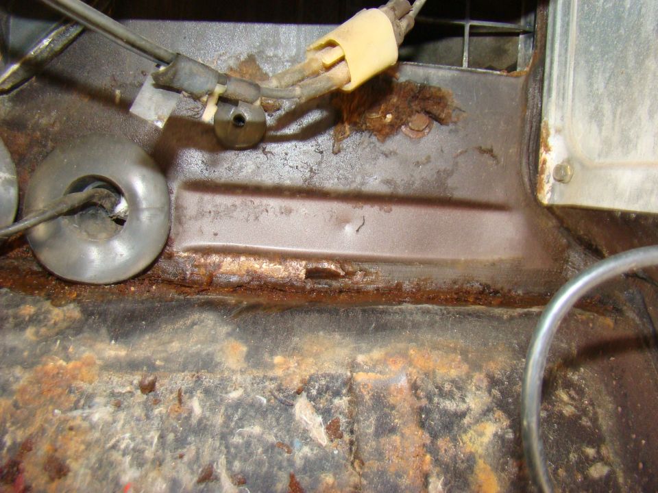 Heavily rusted metal components with wires and circular metal parts.