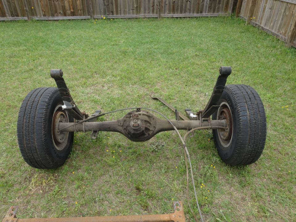 Rear axle assembly with tires and leaf springs on grass