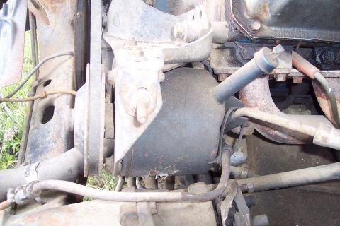 1973 Ford F-250 - This is a close-up view of the engine bay of a vintage Ford F-250, focusing on the engine mount and various hoses and belts. The engine app…