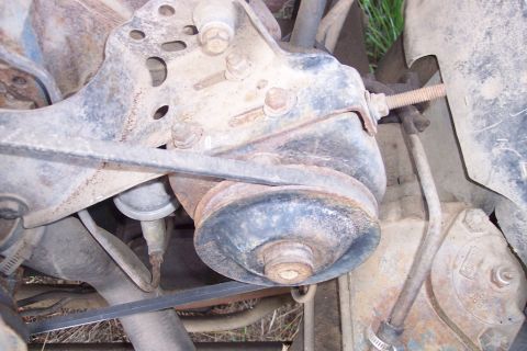 1973 Ford F-250 - This is a close-up, low-angle shot of the engine bay of a 1973 Ford F-250, focusing on the power steering pump and belt system. The compone…