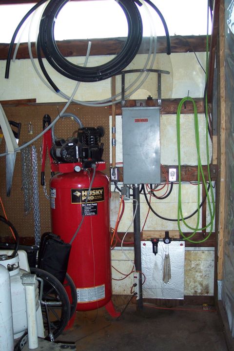 1990 Ford Bronco - A red Husky Pro air compressor with a black motor sits in a workshop setting. Various hoses, electrical components, and tools are visible i…