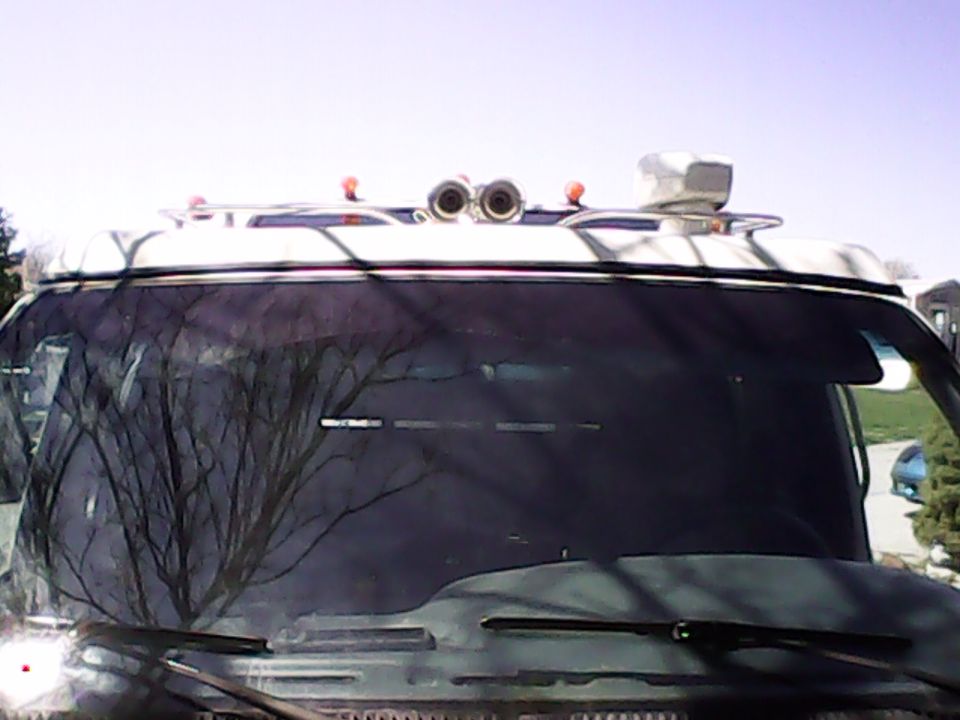 White van front view with chrome air horns and roof accessory