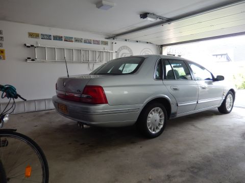 1999 Ford Fairlane - Silver sedan parked in a garage with the rear facing the camera.