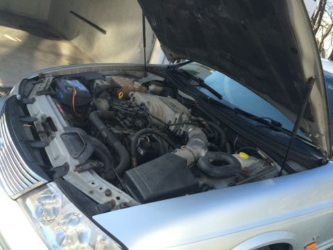 1999 Ford Fairlane - Engine bay of a 1999 Ford Fairlane, hood raised for access.