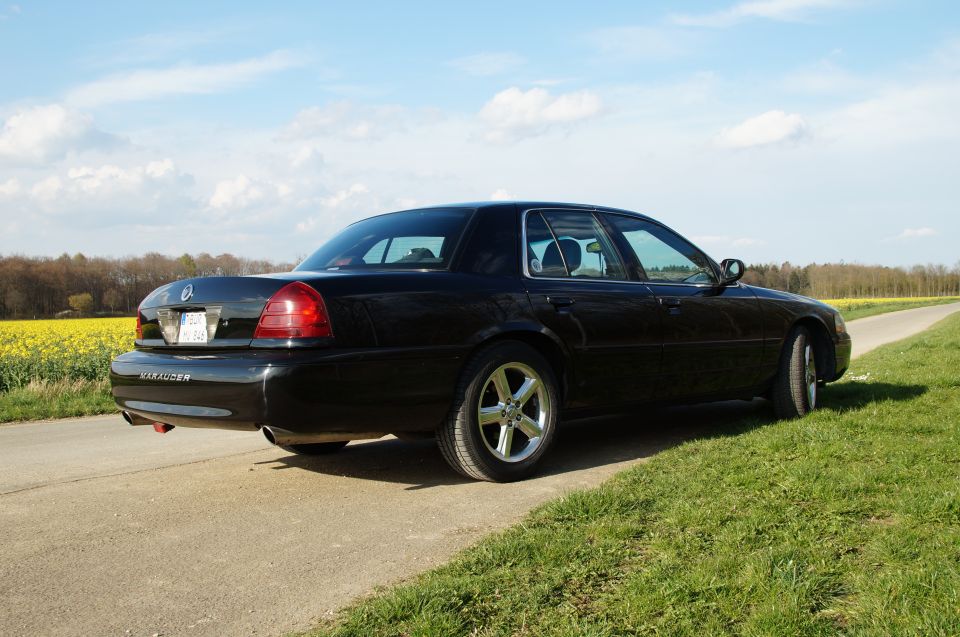 2003 Mercury Marauder parked on a dirt road with a field of yellow flowers in the background