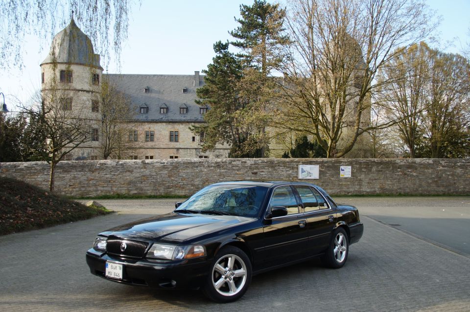 Black 2003 Mercury Marauder parked outside a stone building with a tower