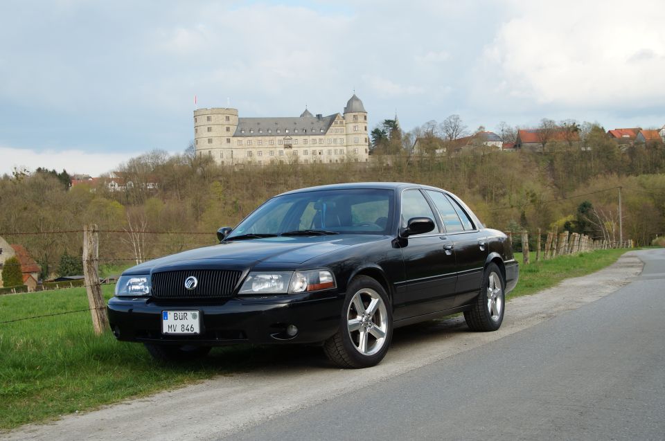Black 2003 Mercury Marauder parked roadside, castle in background