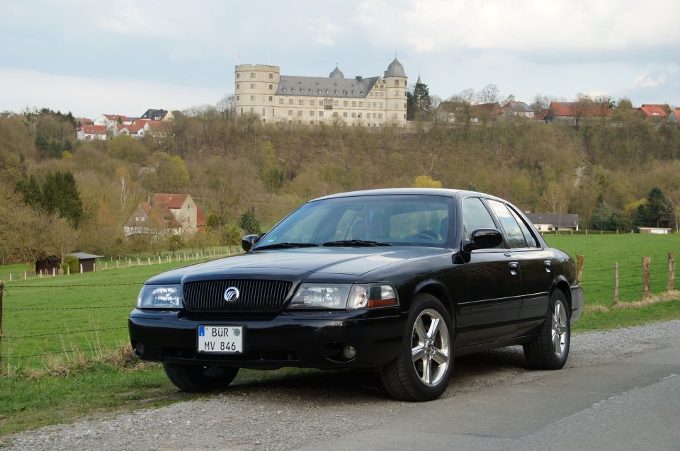 Black 2003 Mercury Marauder parked on a gravel road with a castle in the background