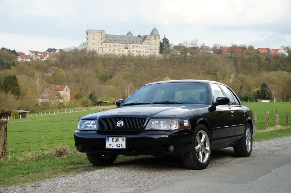 Black 2003 Mercury Marauder parked on a gravel road with a castle in the background