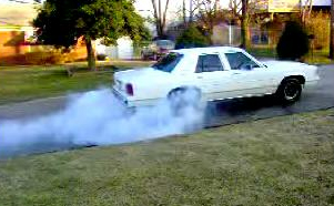 1991 Ford Crown Victoria LTD - A white 1991 Ford Crown Victoria LTD is seen performing a burnout on a residential street.