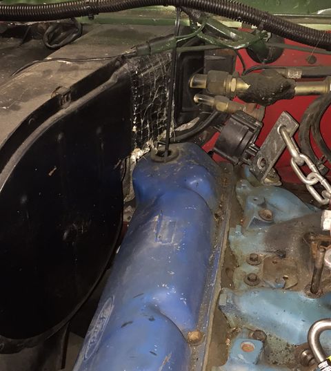 1978 Ford Bronco - Close-up view of engine components, including blue valve covers and various hoses and wires.