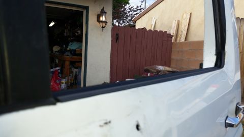 1992 Ford Bronco - View from inside a vehicle looking out towards a garage and a wooden fence.