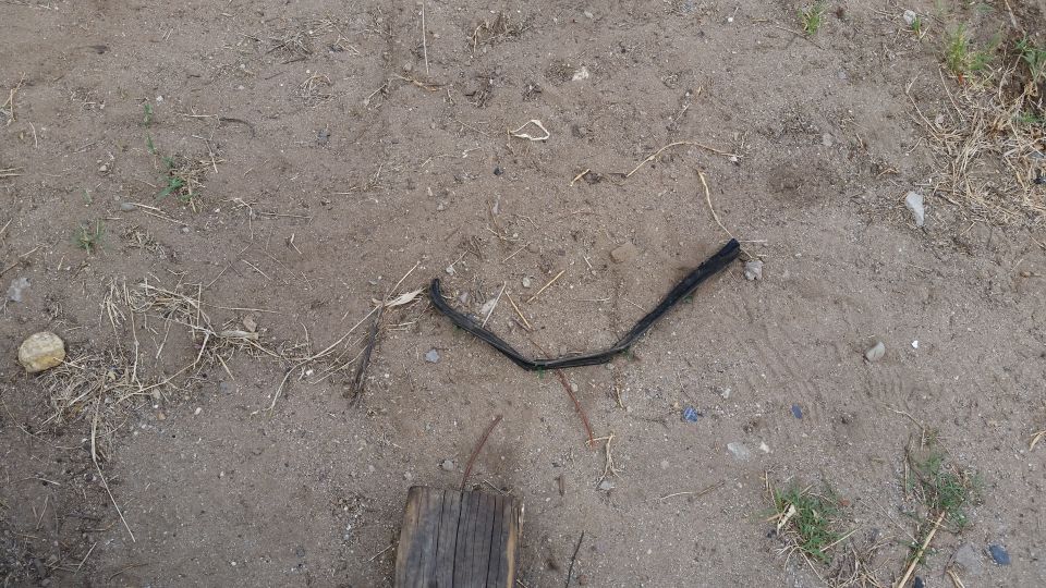 Black rubber trim piece on dirt ground with Supermotors logo