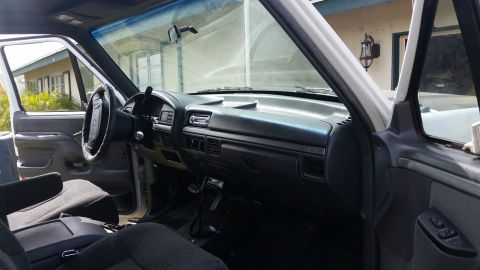 1992 Ford Bronco - The interior of a truck is shown, the dashboard, steering wheel, and seats.