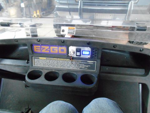 1992 Ford Bronco - Interior view of a golf cart dashboard the EZGO brand and a digital readout.