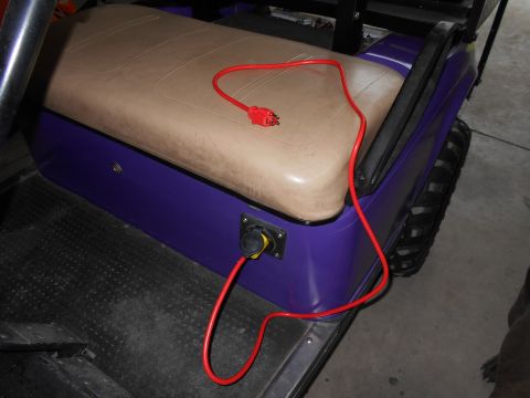 1992 Ford Bronco - Golf cart interior showing a red charging cord connected to the side of the vehicle.