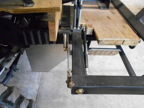 1992 Ford Bronco - Close-up view of a vehicle's undercarriage and a wooden platform structure.