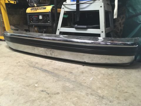 1993 Ford Bronco - Chrome bumper with black trim, likely for an older truck or SUV, seen indoors.