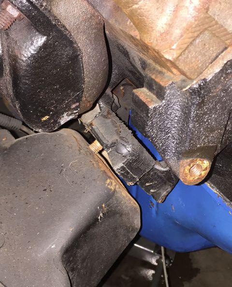 1978 Ford Bronco - Close-up view of a worn engine mount, indicating potential mechanical issues.