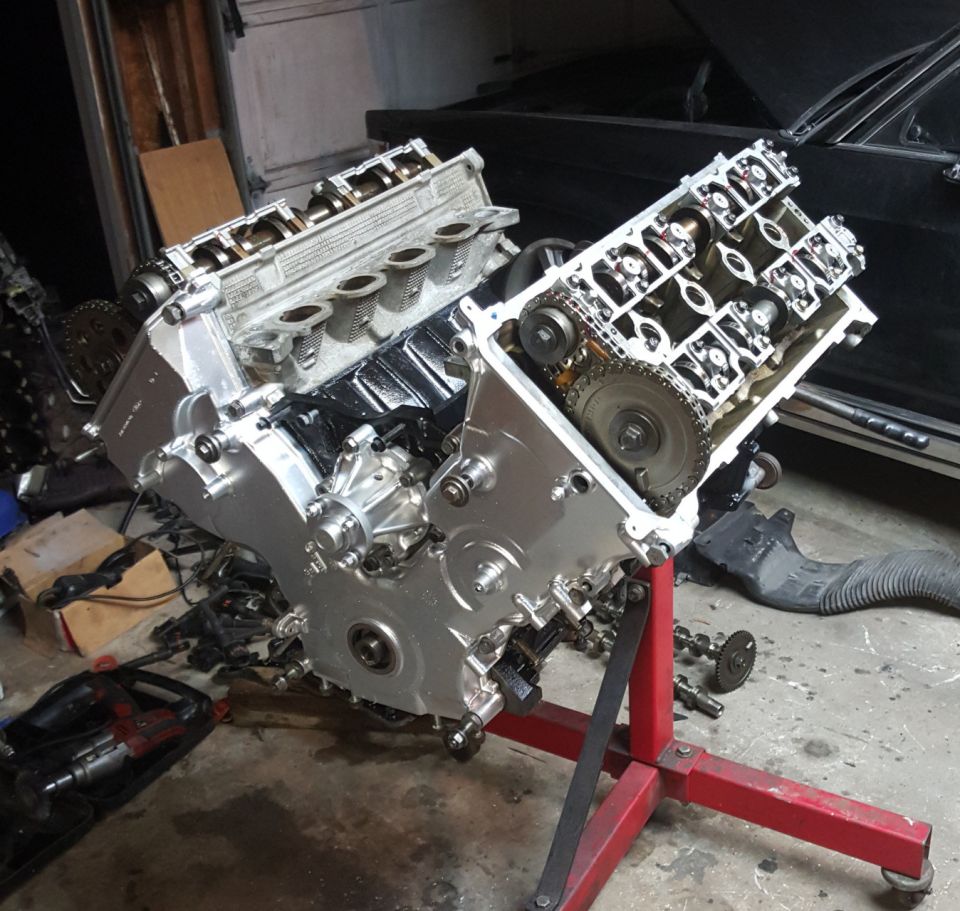 Engine on red stand, showing valve covers and timing chain