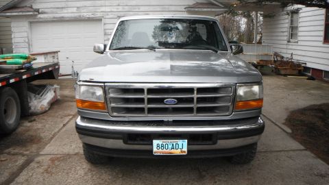 1995 Ford F-150 - This 1995 Ford F-150 pickup truck is shown from the front in a driveway with a garage behind it.