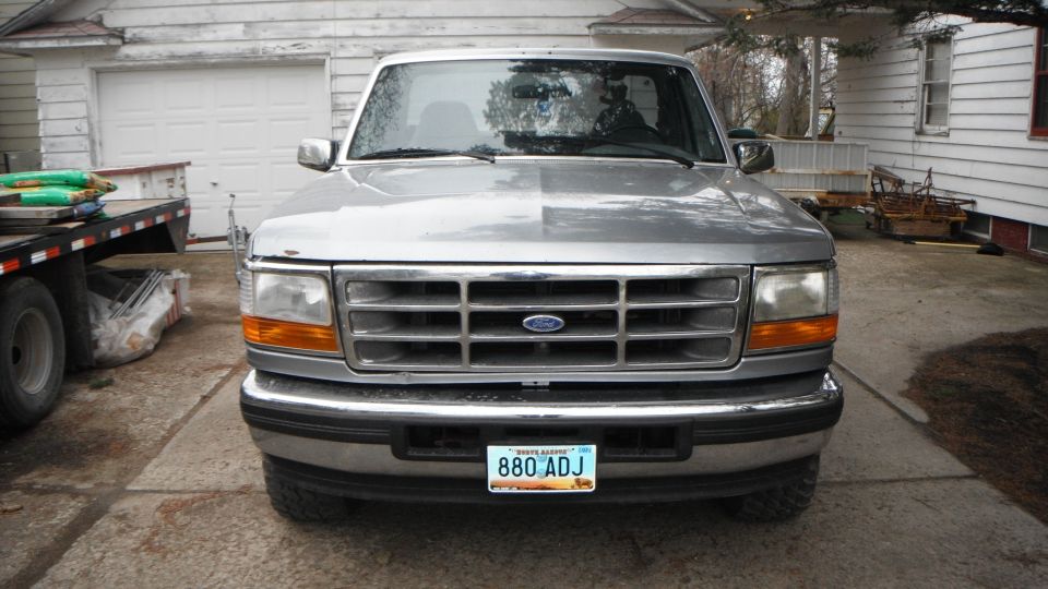 Front view of a silver 1995 Ford F-150 pickup truck parked in a driveway