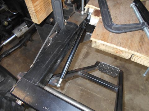 1992 Ford Bronco - Vehicle part secured with clamps and wood blocks, possibly during repair or fabrication.