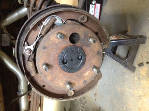 1973 Ford Bronco - The interior of a drum brake assembly is shown, with the brake drum removed. Various springs, brake shoes, and hardware are visible, all sh…