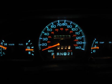 1994 Ford Crown Victoria - Illuminated dashboard gauges display speed, fuel level, voltage, and temperature in a vehicle's interior.