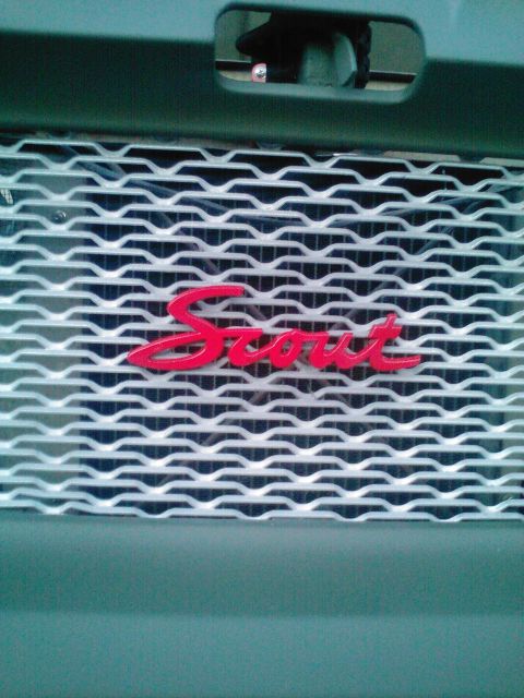 1991 Ford Bronco - A close-up shot shows the red "Scout" lettering on the front grille of a dark green vehicle.