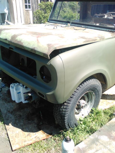 1991 Ford Bronco - The front fender and hood of a vintage utility vehicle are shown, painted in a matte olive drab. The vehicle appears to be undergoing resto…