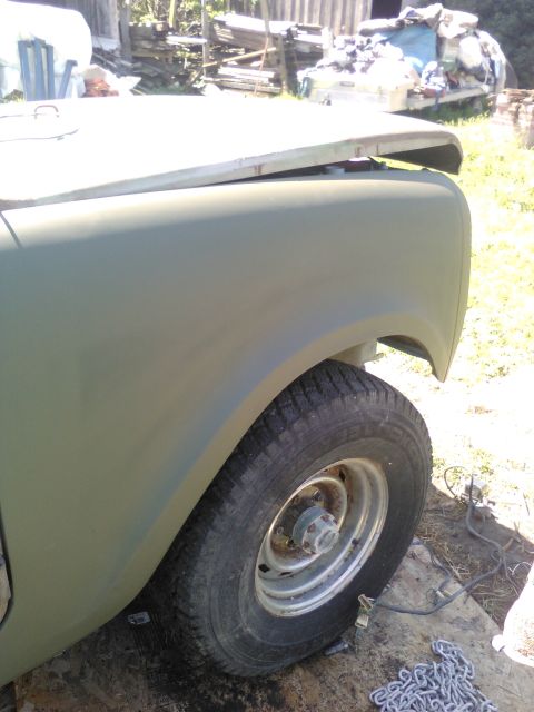 1991 Ford Bronco - The front fender and hood of a green vehicle are shown in a close-up, side view. The vehicle appears to be undergoing some form of restorat…