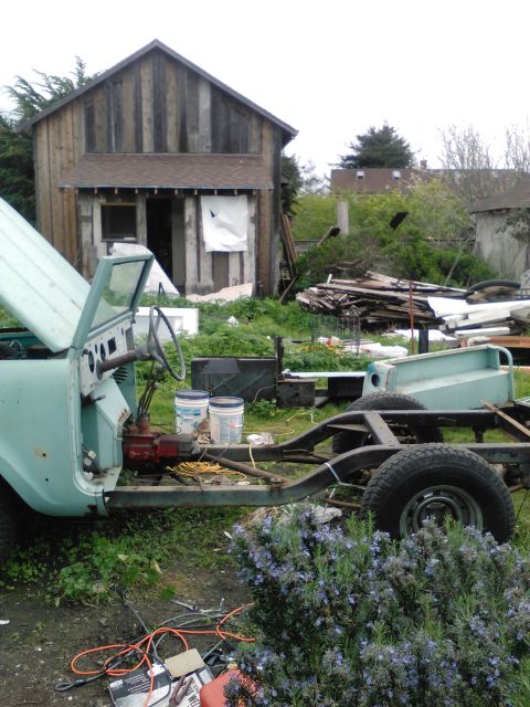 1991 Ford Bronco - A partially disassembled light blue vehicle, possibly a Jeep CJ or similar utility vehicle, sits in a yard with a wooden shed in the backgr…