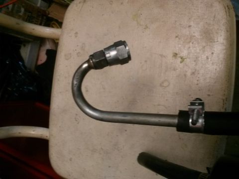 1996 Ford Bronco - A close-up view of a metal hose with a clamp attached to a black hose, likely part of a vehicle's fluid system.