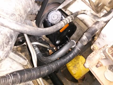 1996 Ford Bronco - This close-up view shows the power steering fluid reservoir and associated hoses in an engine bay. A black serpentine belt is visible above…