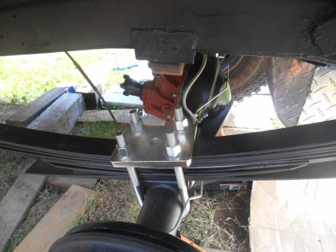 1972 Ford Bronco - Underneath view of a vehicle's rear suspension, showing leaf springs, U-bolts, and a differential housing. A metal plate secures the leaf s…