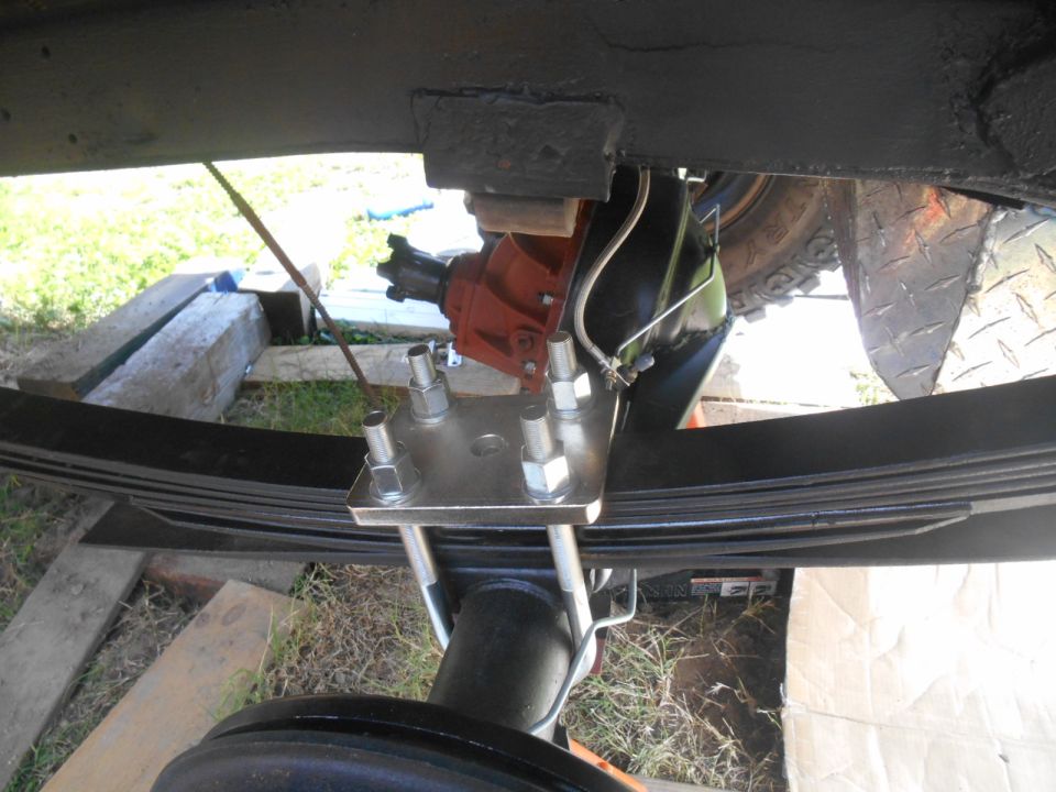 Vehicle rear suspension with leaf springs, U-bolts, and differential.