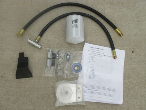 2007 Ford F-250 - A collection of parts for a coolant filter system is laid out on a neutral surface.
