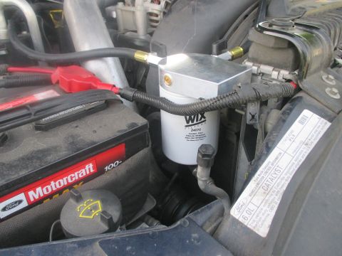 2007 Ford F-250 - Close-up of a WIX coolant filter installed in the engine bay next to the battery.