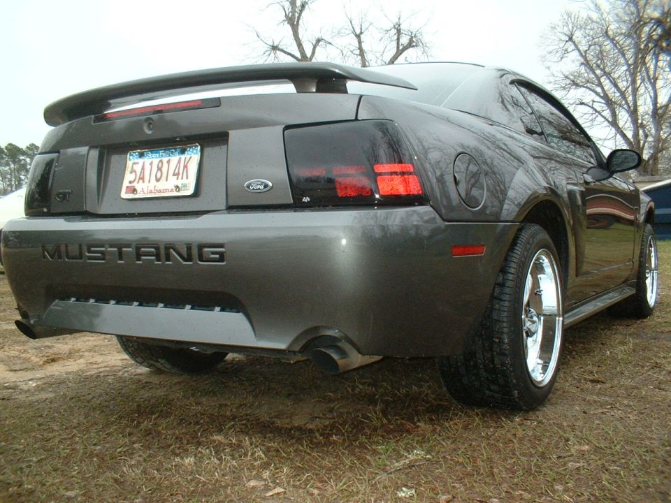 Rear view of a 2003 Ford Mustang with a spoiler and chrome wheels