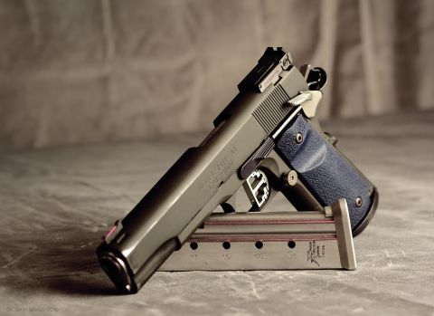 1996 Ford Bronco - A close-up of a Springfield Armory 1911 pistol with blue grips, displayed on its magazine.