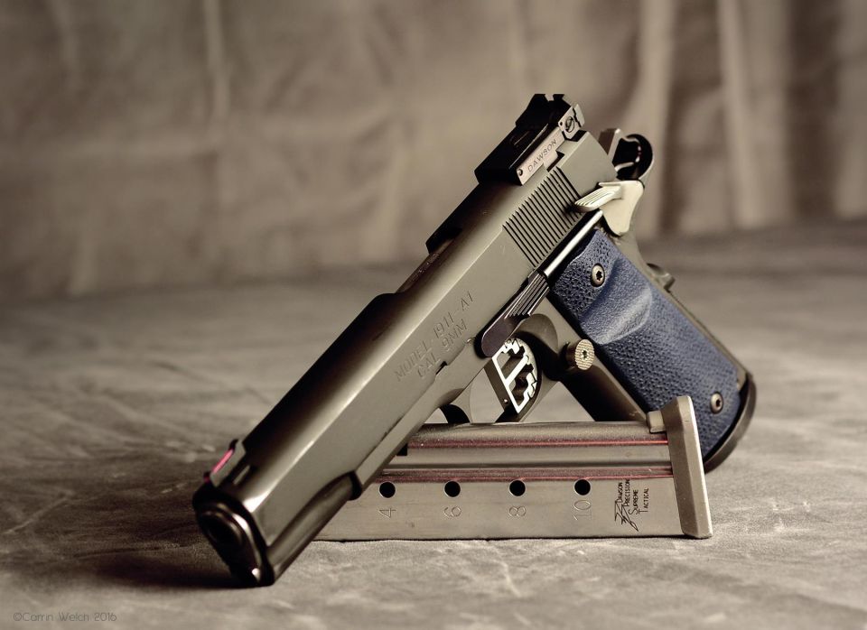 Springfield Armory 1911 pistol with blue grips, resting on its magazine