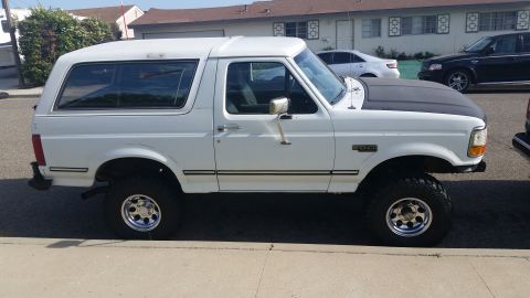 1992 Ford Bronco - Side view of a white 1992 Ford Bronco with a black aftermarket hood.