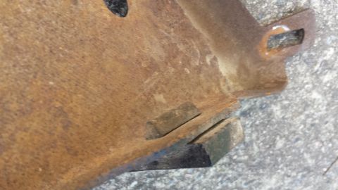 1976 Ford Ranchero - A heavily rusted metal component, possibly a bumper bracket, is shown in a close-up view.