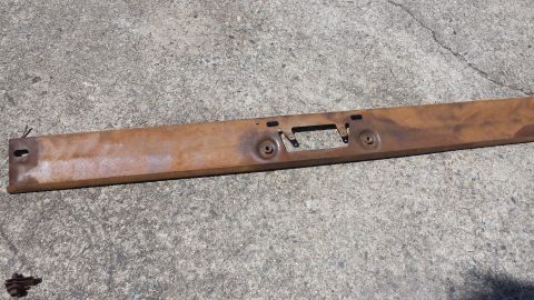 1976 Ford Ranchero - A weathered metal piece lies on a concrete surface, showing signs of rust and wear.