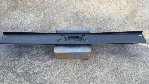 1976 Ford Ranchero - This black bumper part features mounting holes for a license plate and is shown on a concrete surface.