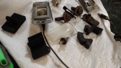 1976 Ford Ranchero - Various automotive parts, including rubber bumpers and hardware, laid out on a towel.
