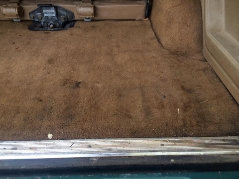 1990 Ford Bronco - Interior cargo area carpet shows wear and stains.